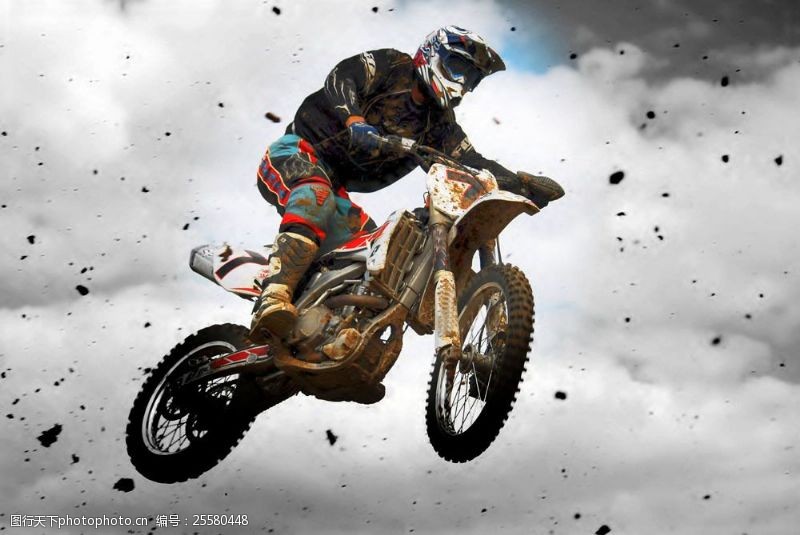 越野摩托车飞跃跳跃的越野摩托车和飞起的泥土图片