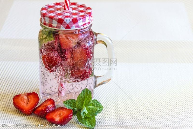 薄荷叶在近一半白玻璃容器切片草莓果实