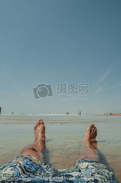 beach人穿着乱画沙滩裤坐在表面水