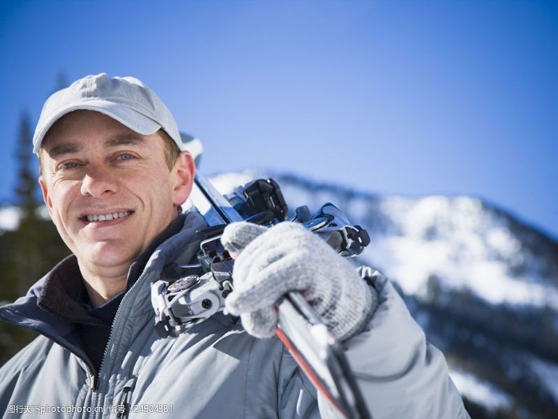 滑雪场肩扛滑雪工具的男性图片