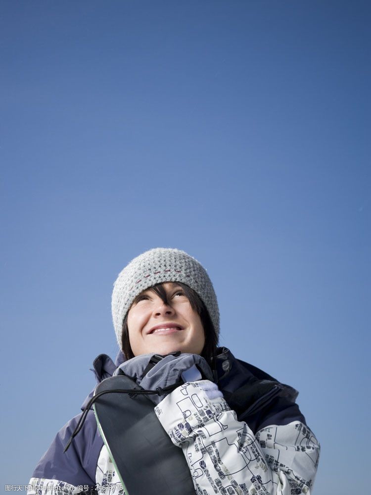 滑雪场抱着滑雪板微笑的女性图片