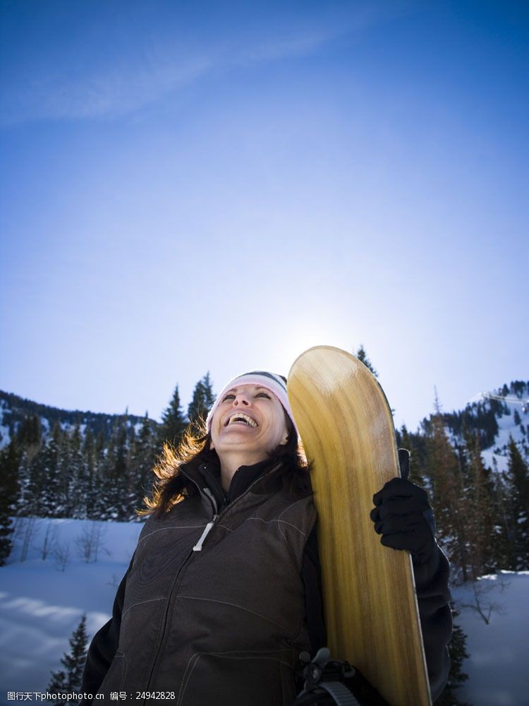 滑雪场手拿滑雪板灿烂微笑的女性图片