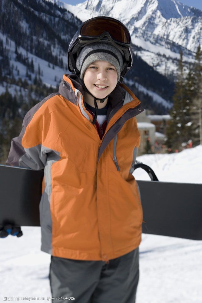 滑雪场拿滑雪板的男孩图片