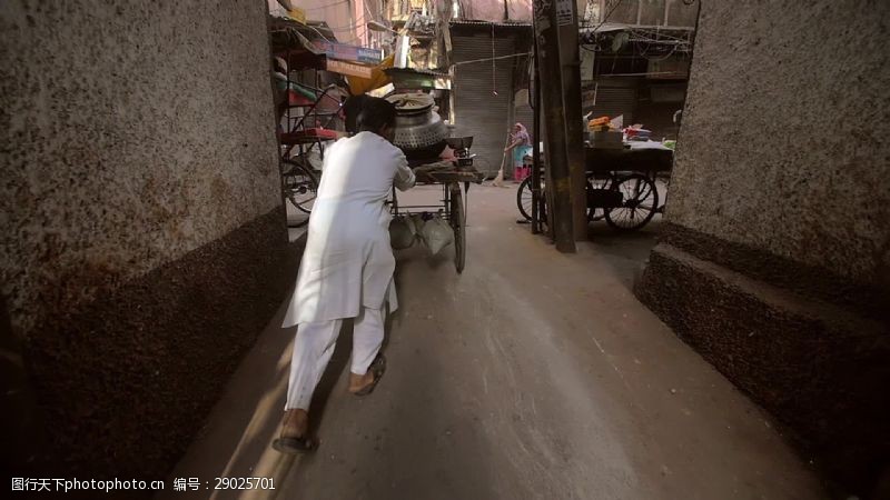狭窄印度男子推车沿着小巷